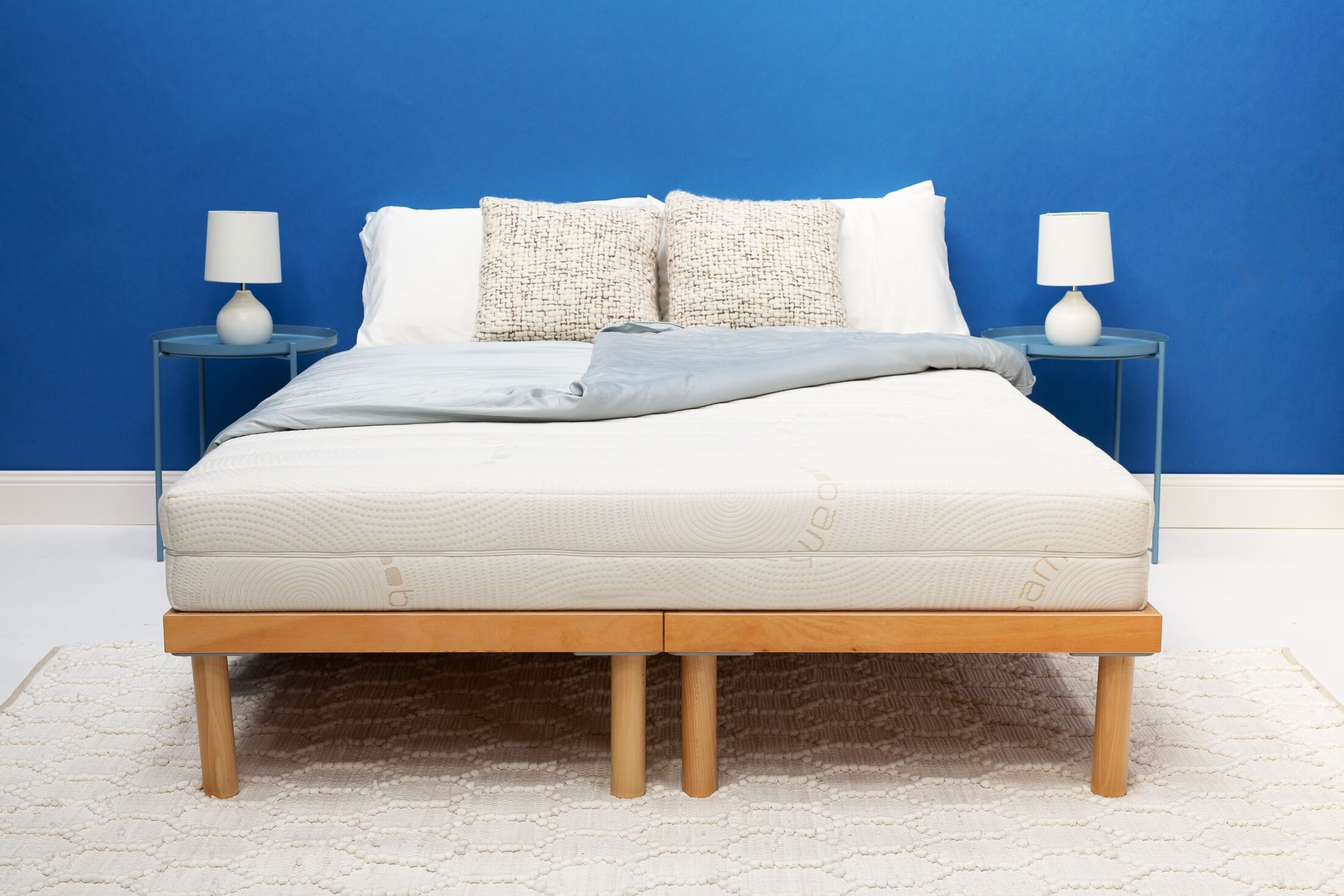 Zenna latex mattress dressed with white linen, textured cushions and grey throw on timber bed frame
