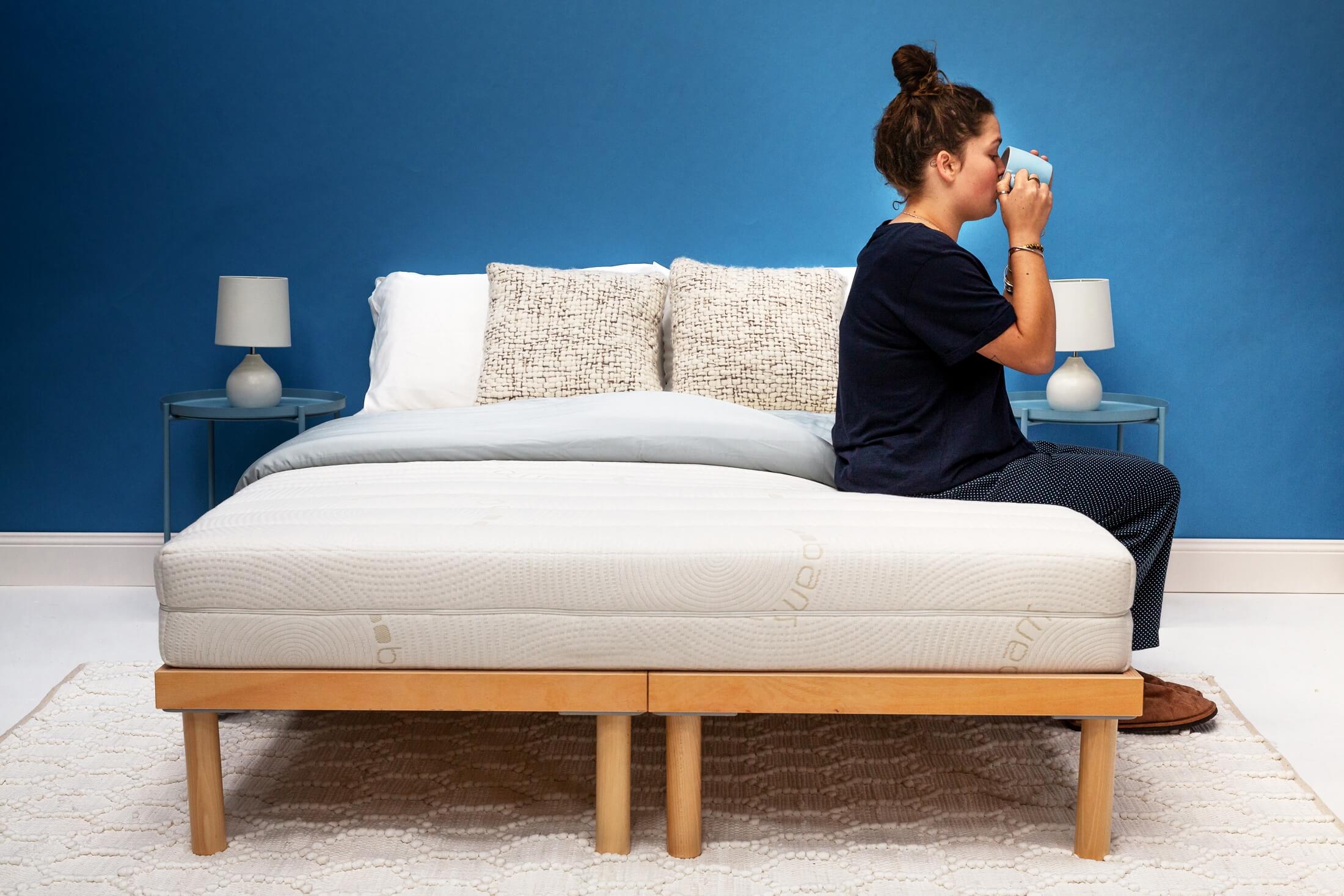 Side profile of Zenna latex mattress on natural timber bed frame, showing 20cm bamboo-covered thickness